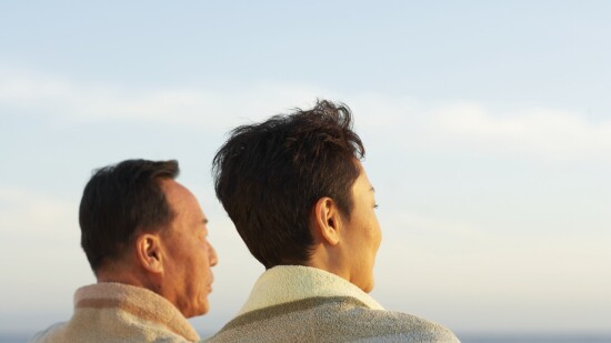 Una pareja madura en la playa, vista lateral, cabeza y hombros