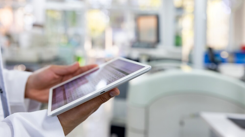 研究室で作業中にデジタルタブレットを使用する科学者